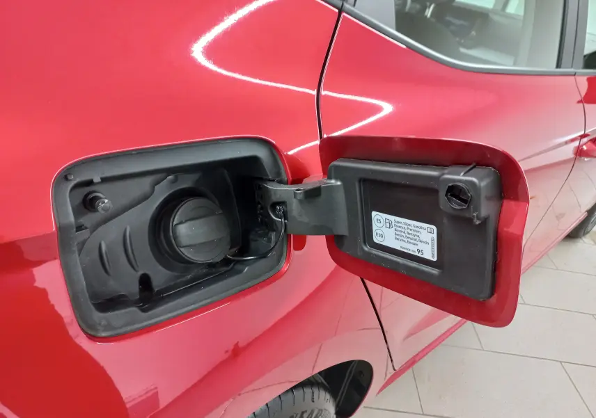 Vue rapprochée de la trappe à carburant ouverte côté gauche d'une SEAT Ibiza rouge désir 2025 essence.