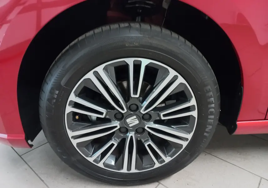 Gros plan sur la roue avant droite d'une SEAT Ibiza 2025 rouge désir avec jante alliage noire et argentée.