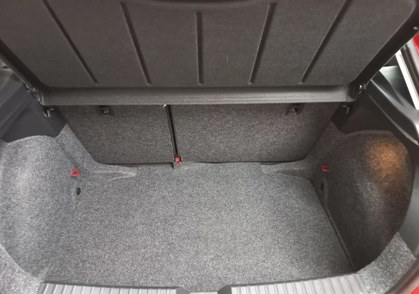 Coffre ouvert de la SEAT Ibiza 2025 rouge désir, vue intérieure montrant le volume et la moquette grise du coffre.