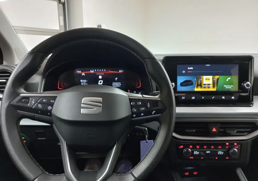 Vue intérieure centrée sur le volant noir et le tableau de bord numérique du SEAT Ibiza 2025, avec écran tactile et commandes visibles.