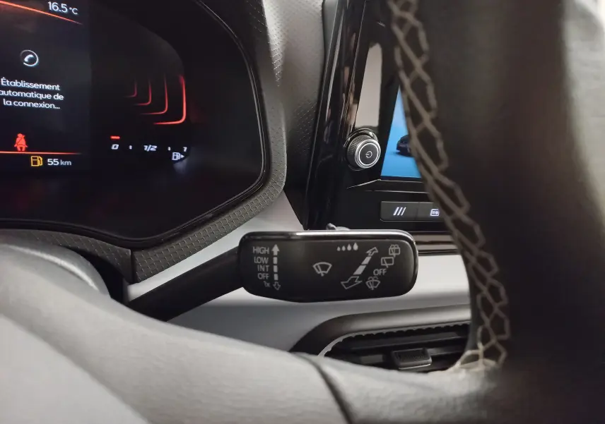 Vue rapprochée du combiné d'instruments et du commodo d’essuie-glace dans l’habitacle d’une SEAT Ibiza 2025 Rouge Désir.