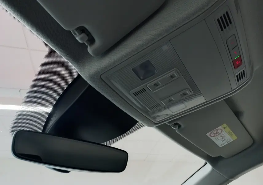 Vue intérieure du plafond avant de la SEAT Ibiza 2025 rouge désir, montrant le rétroviseur et la console de plafonnier avec commandes.