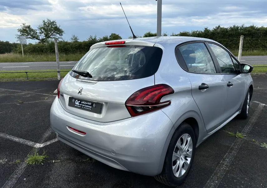 Peugeot 208 gris argent vue 3/4 arrière droit, compacte 5 portes avec feux arrière distinctifs et antenne de toit.