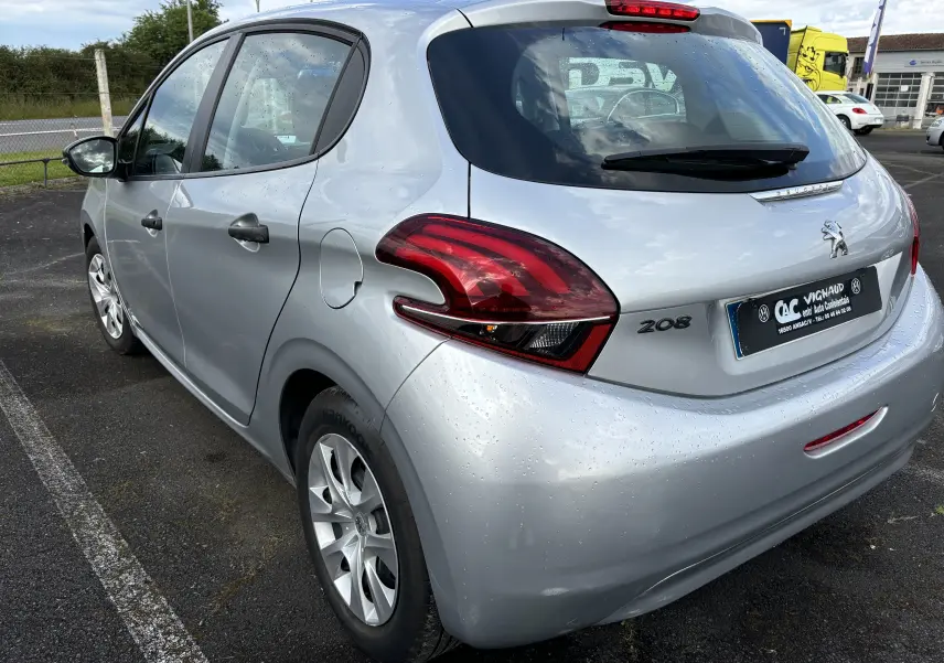 Vue 3/4 arrière droite d'une Peugeot 208 gris argent 2017 avec feux arrière distinctifs et cinq portes visibles.