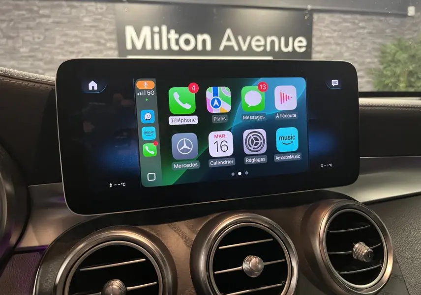 Écran central tactile avec Apple CarPlay dans l'habitacle d'une Mercedes GLC gris, vue rapprochée du tableau de bord.