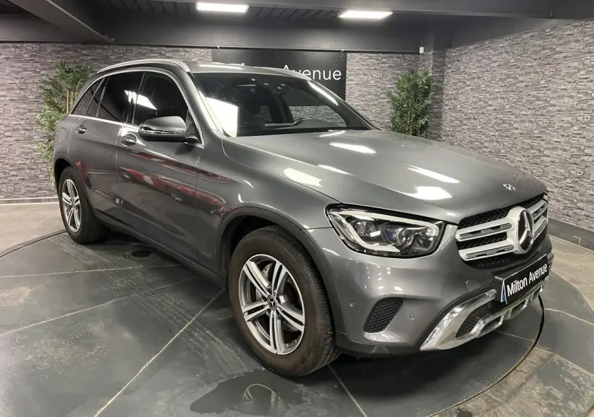 Mercedes GLC 200 4MATIC gris en 3/4 avant droit, avec jantes alliage et calandre chromée en showroom.