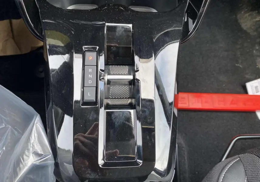 Gros plan sur la console centrale noire brillante avec levier de vitesses automatique de la Citroën C3 Aircross hybride.