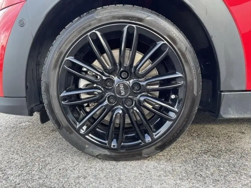 Gros plan sur la roue avant droite noire brillante d'une MINI 5P rouge Edition Camden de 2021.
