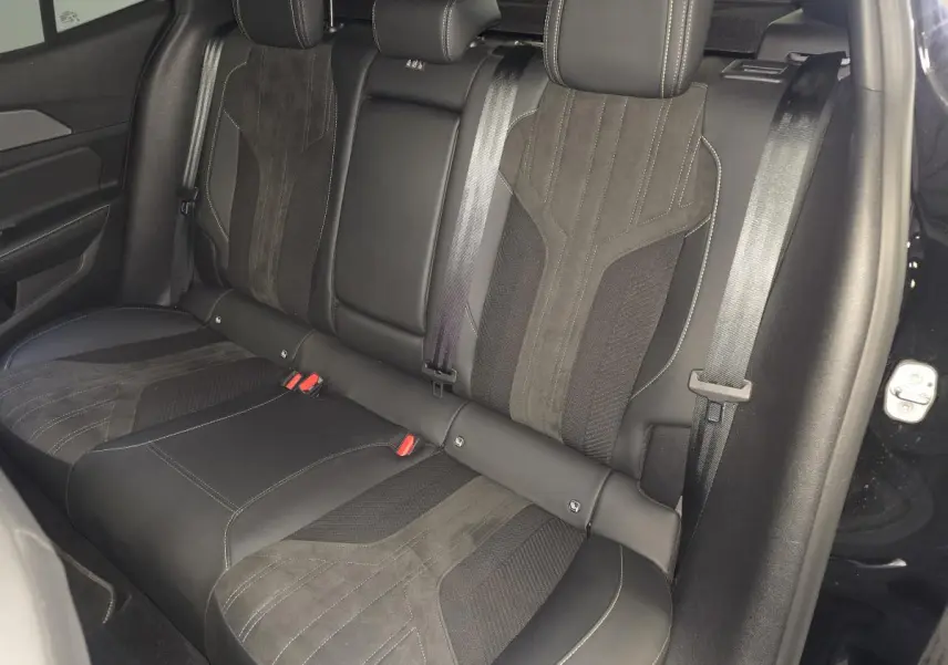 Vue latérale droite de la banquette arrière noire en cuir et tissu du Peugeot 408 1.2i Hybrid GT 2024.