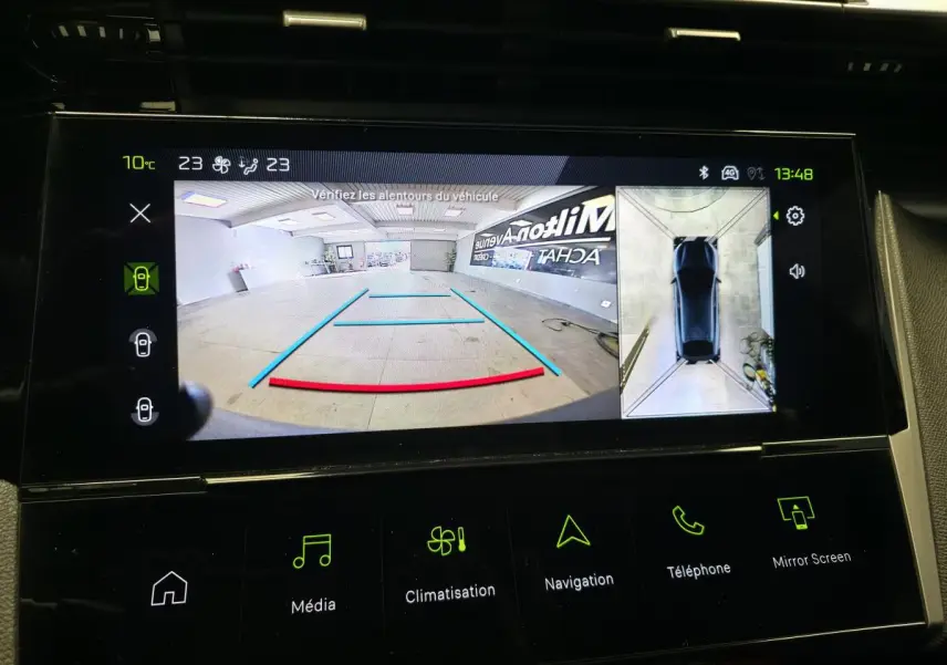 Écran tactile intérieur affichant la caméra de recul et la vue 360° de la Peugeot 408 noire.