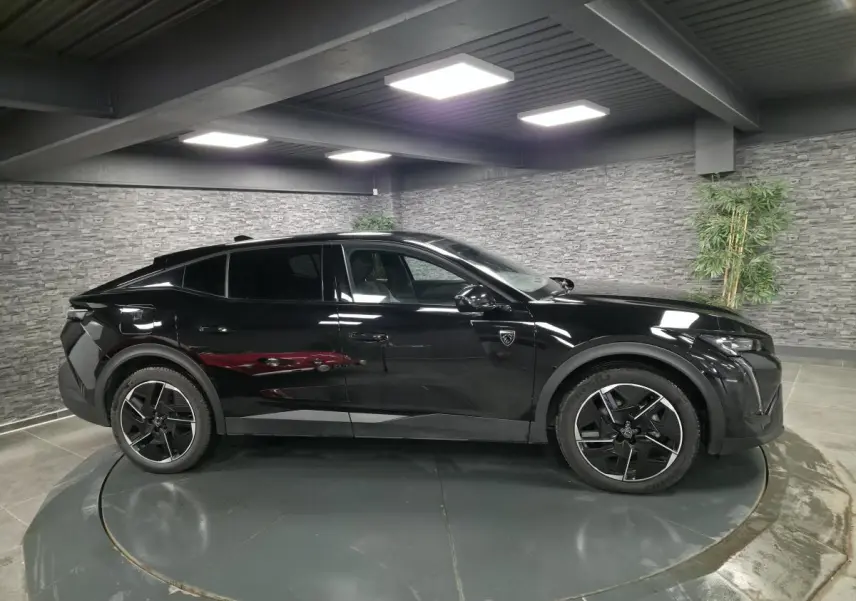 Peugeot 408 noir vue de profil côté gauche, avec jantes alliage 19 pouces et détails noirs brillants.