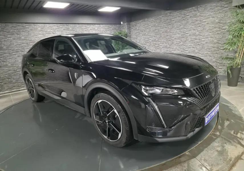 Peugeot 408 noire vue en 3/4 avant droit, avec calandre distinctive et jantes alliage 19 pouces diamantées.
