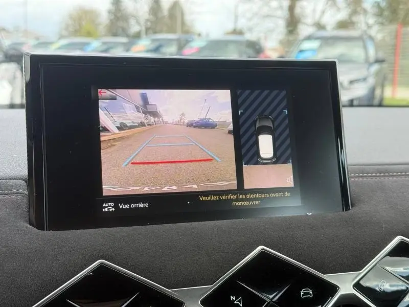 Écran tactile intérieur montrant la caméra de recul et l'aide au stationnement du DS3 Crossback blanc perle toit noir.
