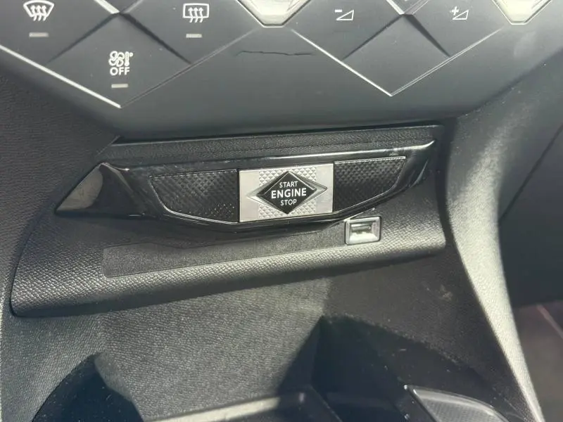 Gros plan sur le bouton Start Engine Stop entouré de détails noirs texturés dans l'habitacle du DS3 Crossback.