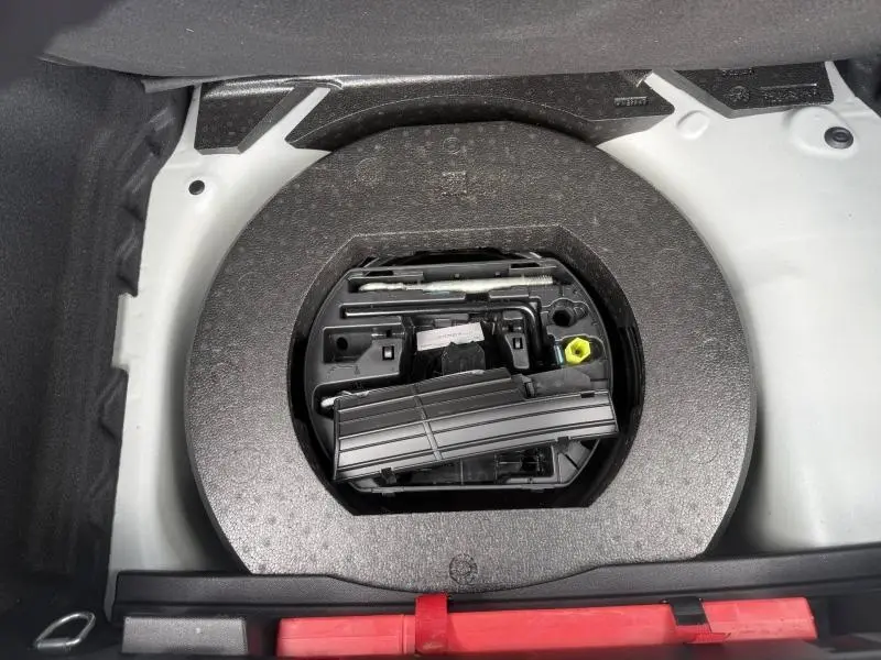 Vue plongeante sur la roue de secours et son rangement dans le coffre d'une DS3 Crossback blanc perle nacré.