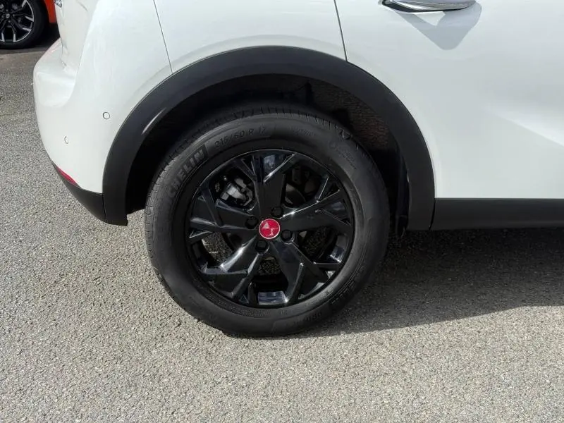 Gros plan sur la roue arrière droite noire brillante du DS3 Crossback blanc perle nacré avec jante Monza 18 pouces.