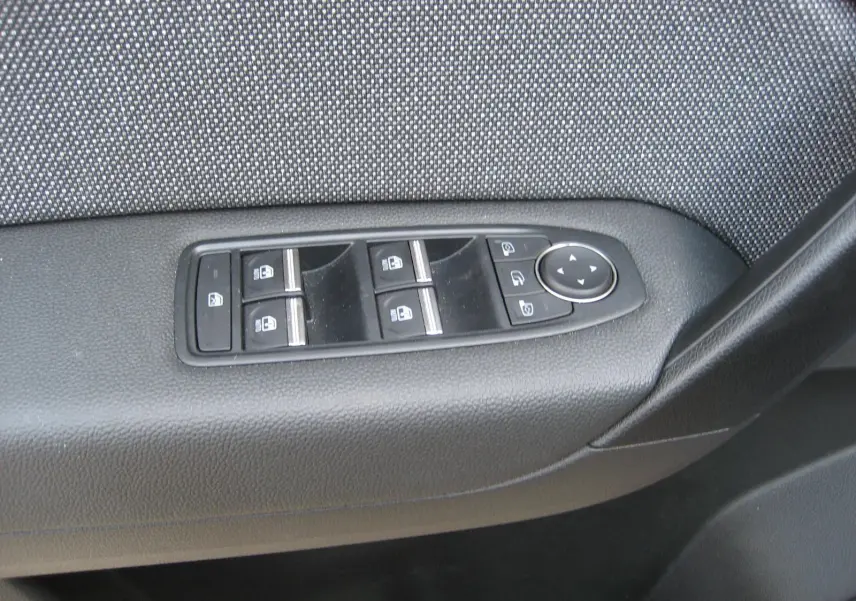 Panneau de commandes des vitres et rétroviseurs côté conducteur de la Renault Symbioz gris Rafale, vue rapprochée intérieure.
