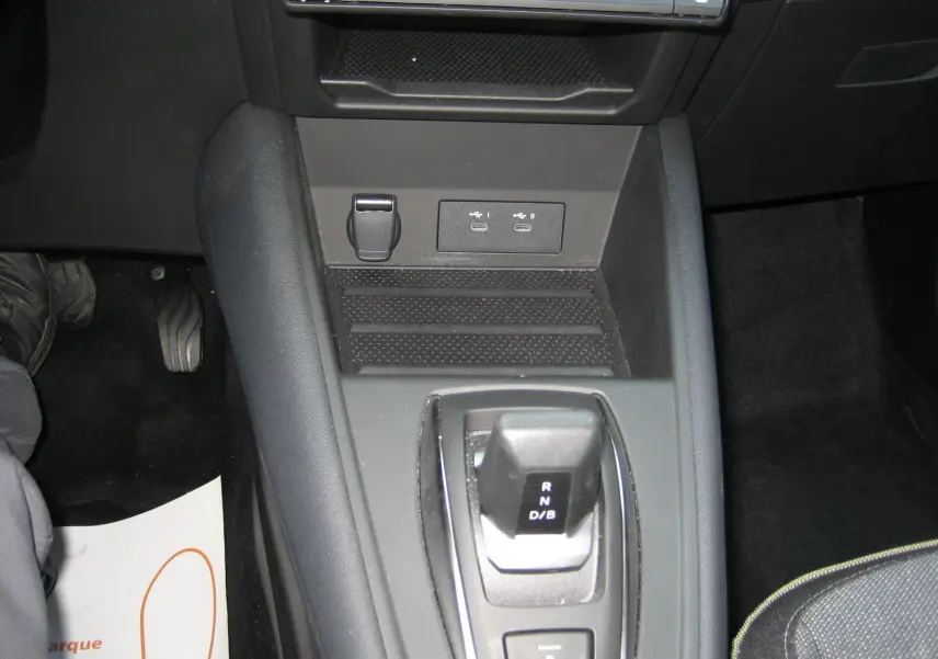 Vue rapprochée de la console centrale noire de la Renault Symbioz 2025, avec levier de vitesses automatique et ports USB visibles.