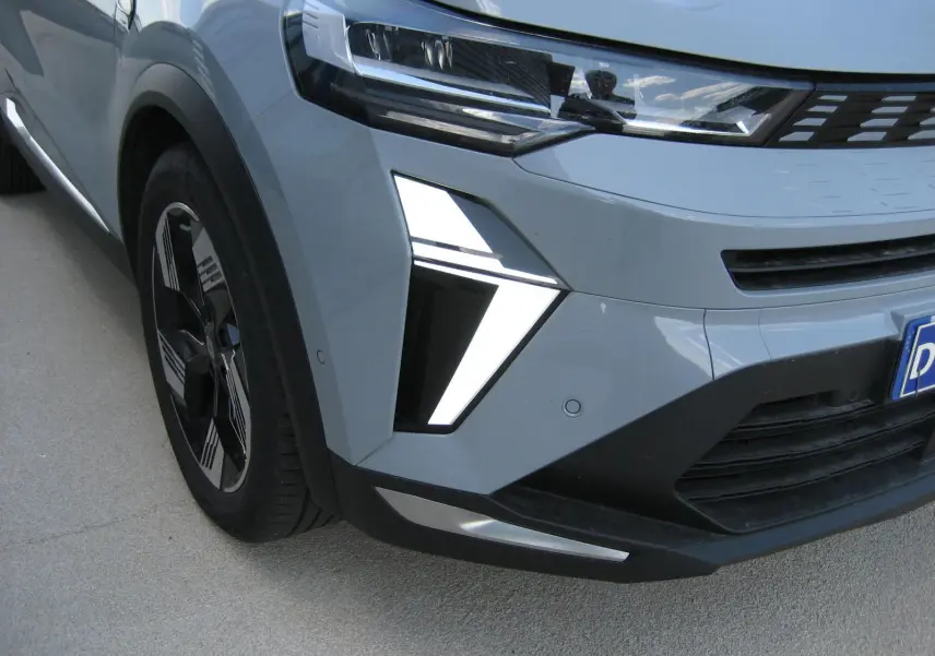 Vue avant droite du Renault Symbioz gris Rafale, mettant en valeur le phare LED et la calandre moderne.