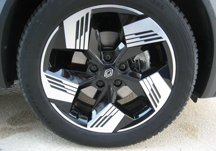 Gros plan sur la jante bicolore noire et argentée du Renault Symbioz gris Rafale, avec logo central distinctif.