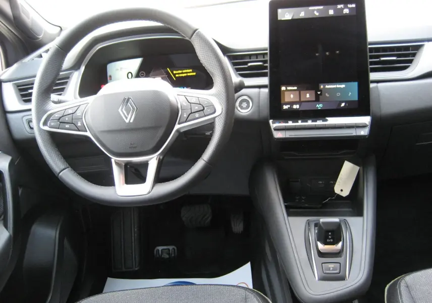 Vue intérieure frontale du tableau de bord gris du Renault Symbioz 2025 avec volant multifonction et écran tactile vertical.