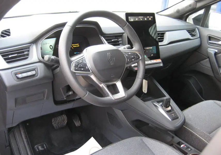 Vue intérieure du poste de conduite du Renault Symbioz gris Rafale, avec volant multifonction et écran tactile vertical.