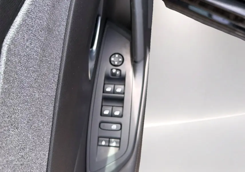 Vue rapprochée des commandes des vitres et rétroviseurs sur la porte côté gauche d’une Peugeot 408 noire.
