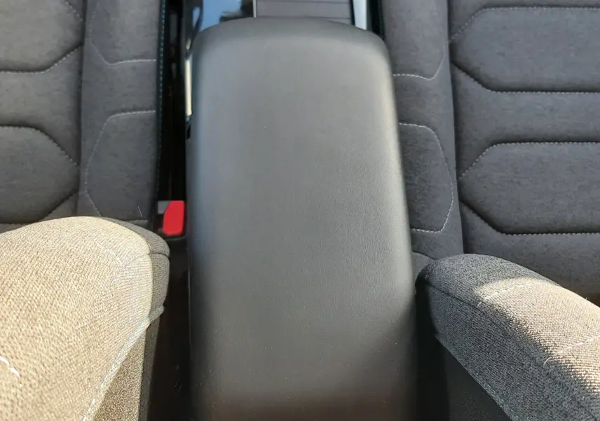 Vue plongeante sur l'accoudoir central noir entre les sièges tissu gris du Citroën C4 2023 version Feel Pack.