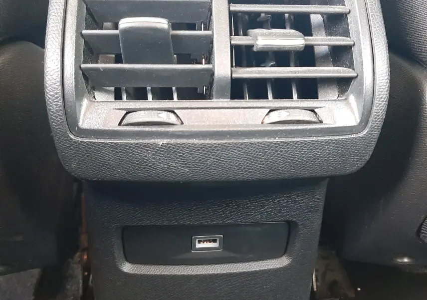 Gros plan sur la sortie d'air arrière noire avec prise USB intégrée dans l'habitacle gris du Citroën C4 2023.