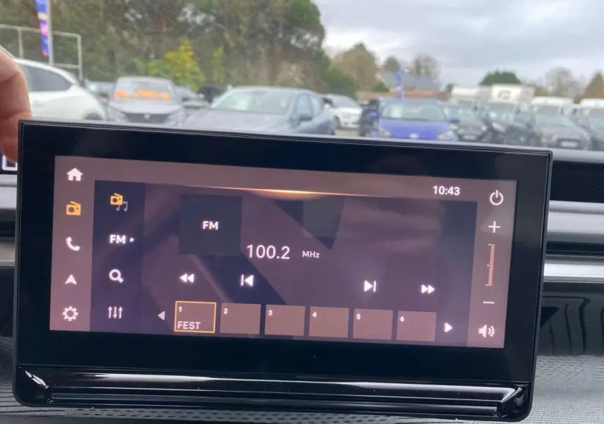 Écran tactile central de la Citroën C3 Aircross 2025 affichant la radio FM à 100.2 MHz en intérieur noir.