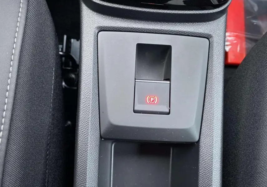 Gros plan sur la commande du frein de stationnement électrique dans la console centrale d'une Citroën C3 Aircross 2025.