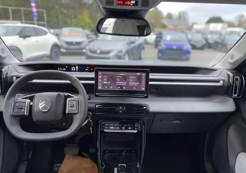 Vue intérieure avant du Citroën C3 Aircross 2025, tableau de bord gris avec écran tactile central et volant multifonctions.