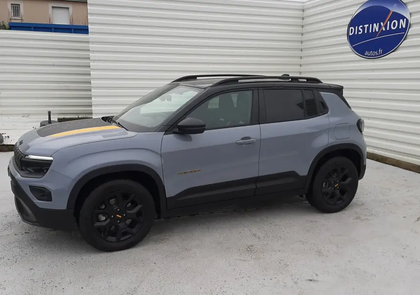 Jeep Avenger 2025 gris Storm avec toit noir, vue de côté droit en extérieur, jantes noires et détails jaunes sur capot.