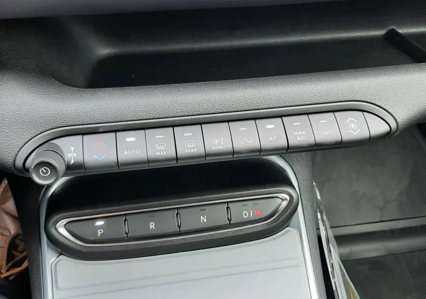 Vue rapprochée de la console centrale du Jeep Avenger 2025, avec commandes de climatisation et boîte auto noire.