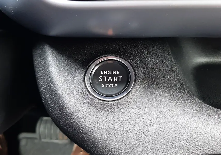 Gros plan sur le bouton moteur start/stop noir entouré de chrome dans l'habitacle du Jeep Avenger 2025.
