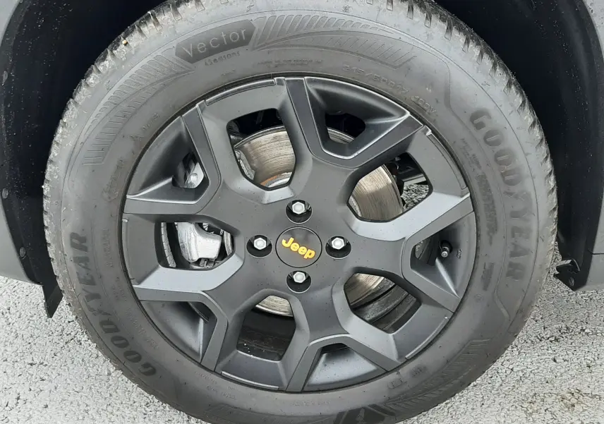 Gros plan sur la roue avant droite noire mate avec logo Jeep jaune du Jeep Avenger Storm Grey 2025.