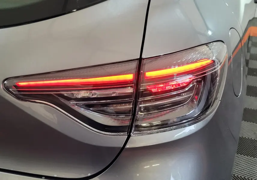 Gros plan sur le feu arrière droit allumé d’une Renault Clio gris foncé Evolution Blue dCi 100 -25, 2025.