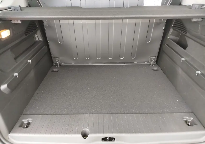 Coffre spacieux vu de l'arrière du Citroën Berlingo 2025 bleu Kiarma, avec revêtement noir et éclairage intérieur.