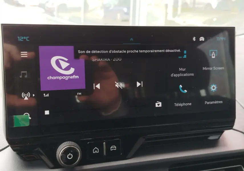 Écran tactile central du tableau de bord du Citroën Berlingo 2025, affichant la radio Champagne FM et les options connectées.