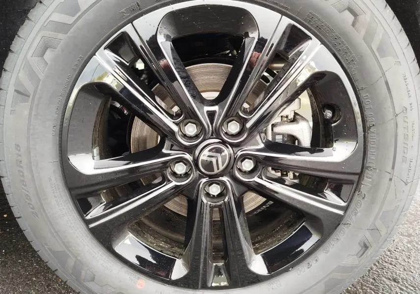 Gros plan sur la jante noire brillante de la Citroën Berlingo 2025, mettant en valeur le logo central et le pneu.