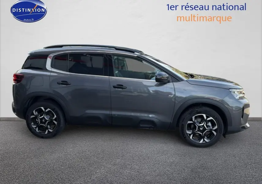 Profil droit du Citroën C5 Aircross gris platinium 2025 avec barres de toit et jantes alu distinctives.