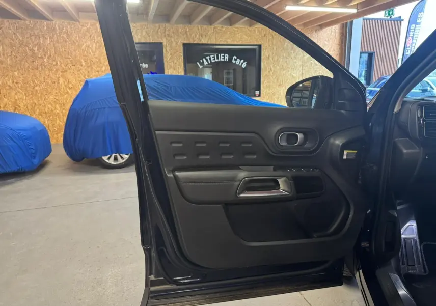 Gros plan sur la jante alu 18 pouces noire et argentée du Citroën C5 Aircross bleu, avec logo Citroën au centre.