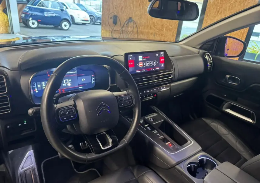 Gros plan sur la porte avant gauche noire du Citroën C5 Aircross avec commandes de vitres et poignée argentée.