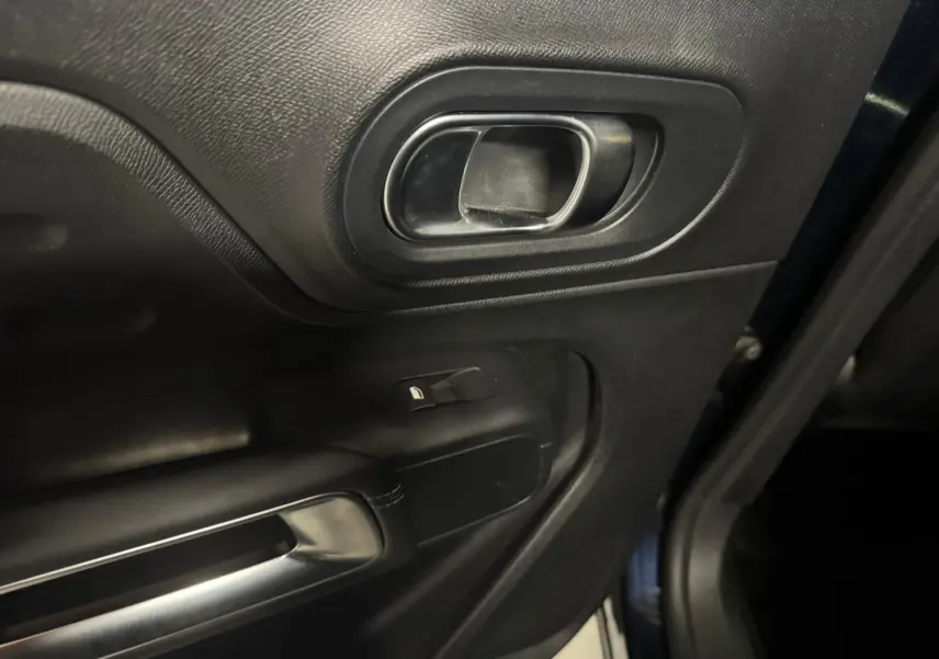 Coffre ouvert vu de l'arrière d'un Citroën C5 Aircross bleu, espace de chargement vide avec éclairage intérieur.