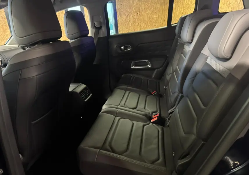Vue intérieure côté droit des sièges arrière en cuir noir du Citroën C5 Aircross bleu, avec appuie-têtes et ceintures visibles.