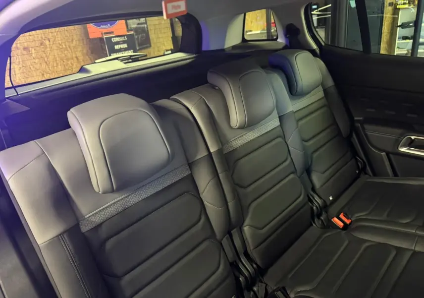 Vue intérieure côté gauche des sièges arrière noirs du Citroën C5 Aircross bleu avec portes ouvertes.