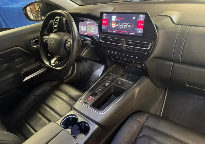 Vue intérieure côté conducteur du Citroën C5 Aircross 2022, sièges cuir noirs avec surpiqûres grises et console centrale visible.
