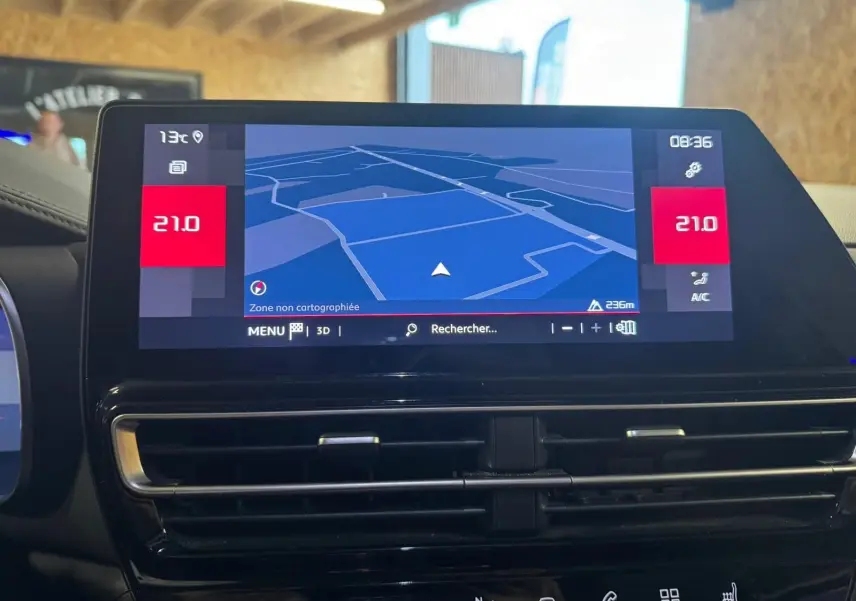 Vue plongeante sur la console centrale noire du Citroën C5 Aircross avec clé, frein à main électrique et porte-gobelets.