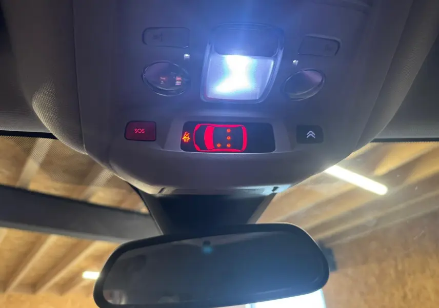 Gros plan sur les commandes de réglage des phares et d’aide à la conduite côté gauche d’un Citroën C5 Aircross bleu.