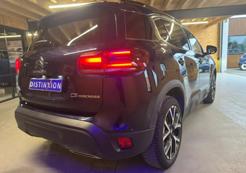 Vue arrière d'un Citroën C5 Aircross bleu 2022 avec feux LED allumés dans un garage.